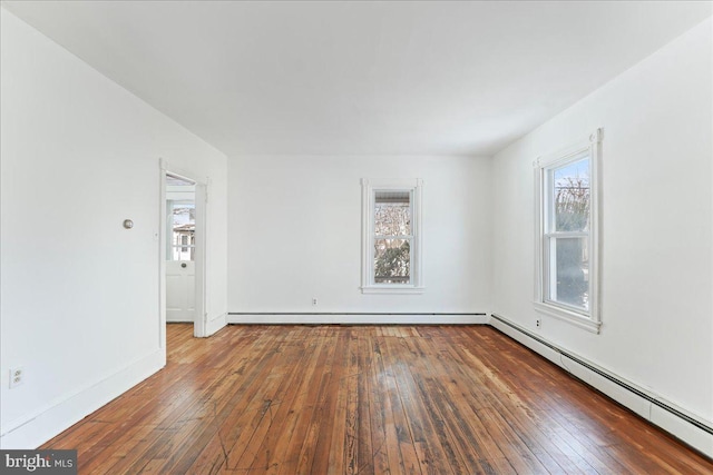 unfurnished room featuring dark wood-type flooring and a baseboard heating unit