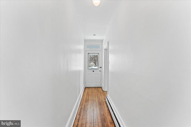 corridor featuring wood-type flooring and a baseboard radiator