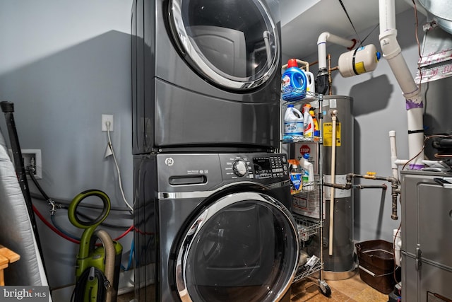 laundry area with gas water heater and stacked washing maching and dryer