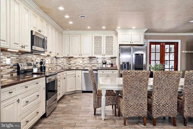 kitchen featuring white cabinets, appliances with stainless steel finishes, and crown molding