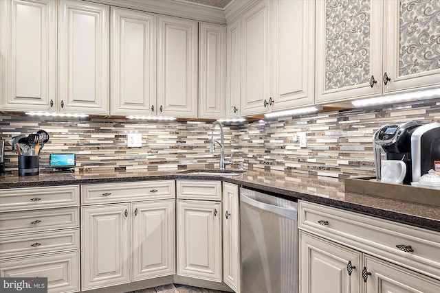 kitchen with sink, backsplash, stainless steel dishwasher, and dark stone countertops