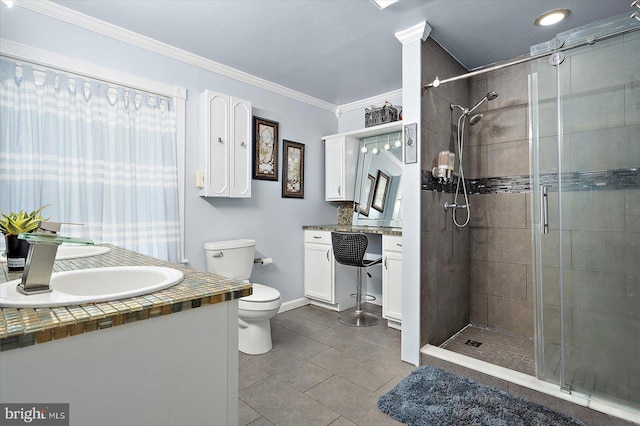 bathroom featuring toilet, crown molding, a shower with shower door, and vanity