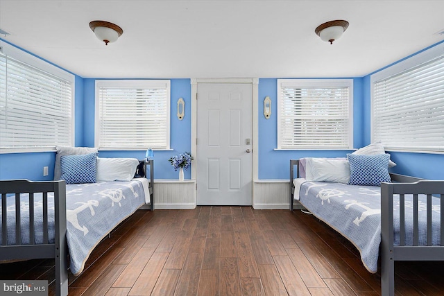 bedroom with dark wood-type flooring and multiple windows