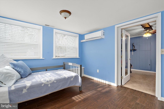 bedroom featuring a wall unit AC, ceiling fan, and dark hardwood / wood-style floors