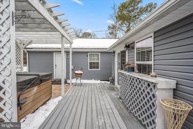 wooden deck featuring a hot tub and a pergola