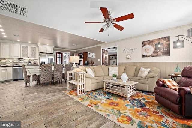 living room featuring ceiling fan and crown molding