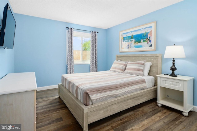 bedroom with dark hardwood / wood-style flooring