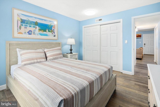 bedroom featuring a textured ceiling, dark wood-type flooring, and a closet