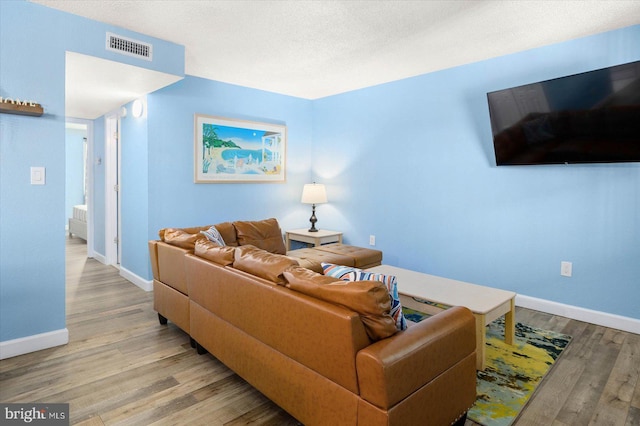 living room featuring a textured ceiling and light hardwood / wood-style floors