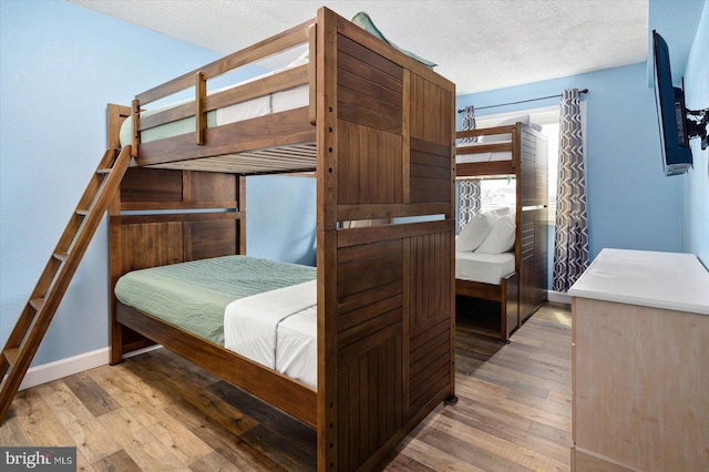 bedroom with a textured ceiling and light hardwood / wood-style floors