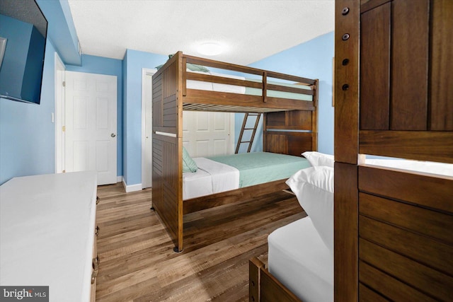 bedroom with a textured ceiling and light wood-type flooring