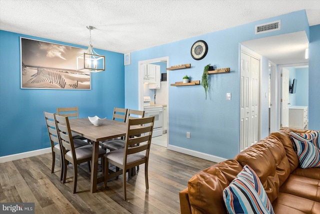 dining room with a textured ceiling and dark wood-type flooring