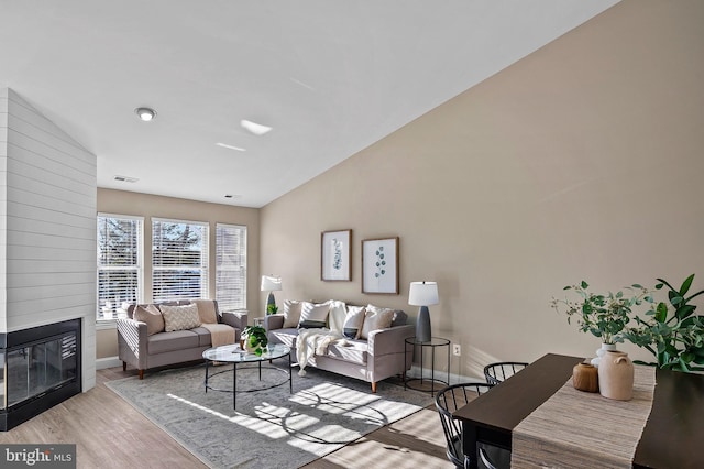 living room featuring a large fireplace and light hardwood / wood-style floors