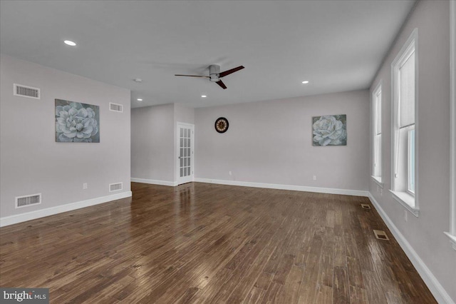 empty room featuring dark hardwood / wood-style flooring, ceiling fan, and plenty of natural light