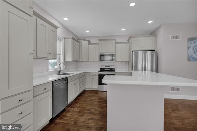 kitchen with white cabinetry, sink, a center island, and appliances with stainless steel finishes