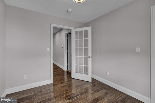 empty room featuring dark wood-type flooring and french doors