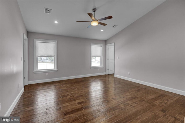 spare room with vaulted ceiling, plenty of natural light, dark wood-type flooring, and ceiling fan