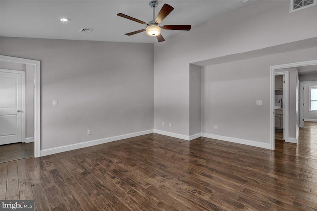 unfurnished room with ceiling fan, dark hardwood / wood-style flooring, sink, and vaulted ceiling