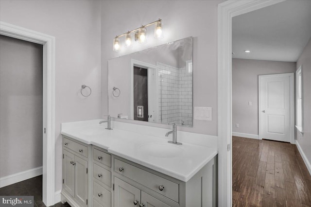 bathroom featuring hardwood / wood-style floors, vanity, and lofted ceiling