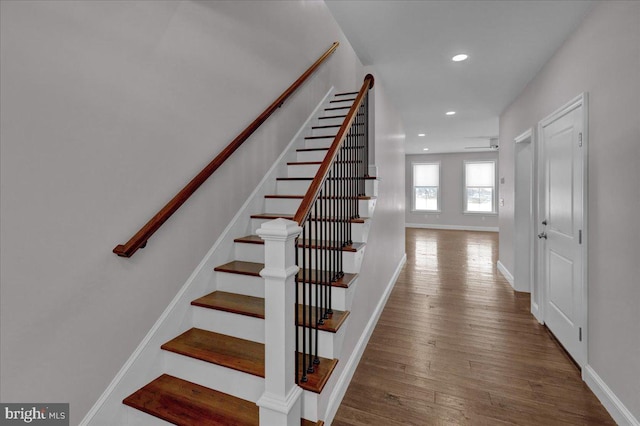 stairway with ceiling fan and hardwood / wood-style floors