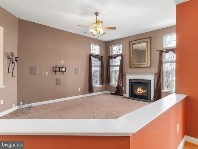 unfurnished living room with carpet floors and ceiling fan