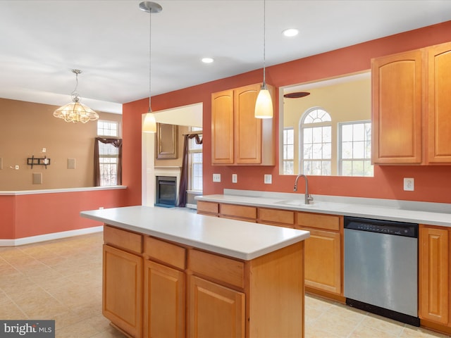 kitchen with a notable chandelier, sink, stainless steel dishwasher, and decorative light fixtures