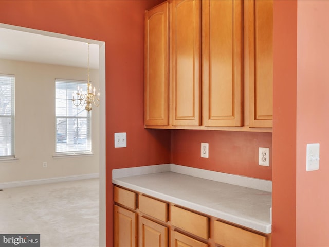 kitchen with hanging light fixtures, light brown cabinets, and a chandelier