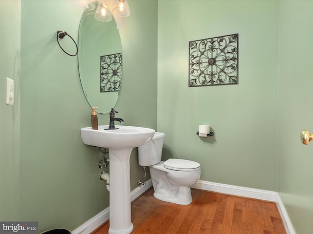 bathroom with toilet and wood-type flooring