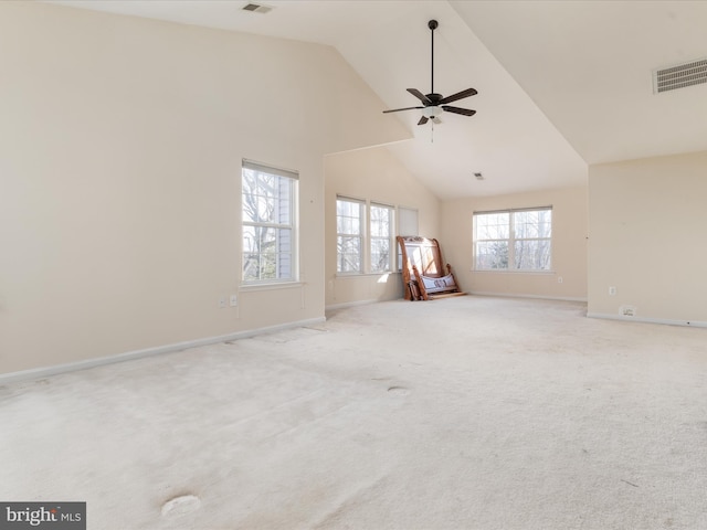 spare room featuring ceiling fan, light colored carpet, and high vaulted ceiling