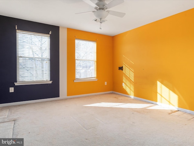 unfurnished room featuring ceiling fan, light colored carpet, and plenty of natural light