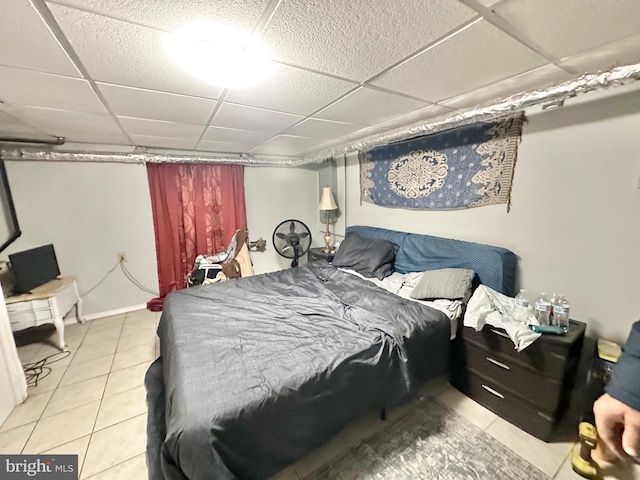 bedroom with light tile patterned floors and a drop ceiling