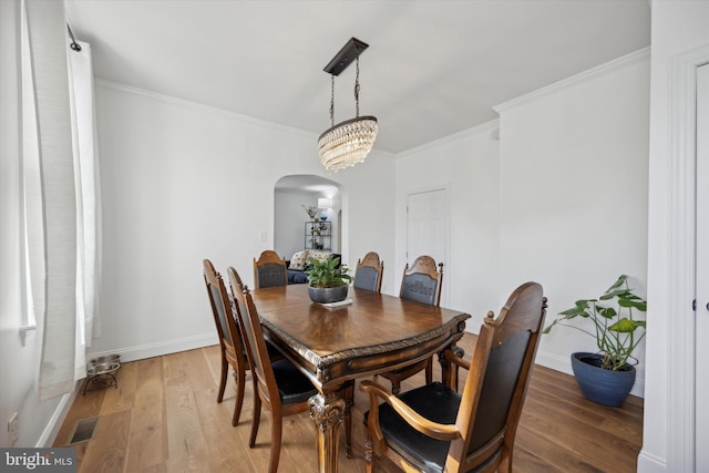 dining area with wood-type flooring and crown molding