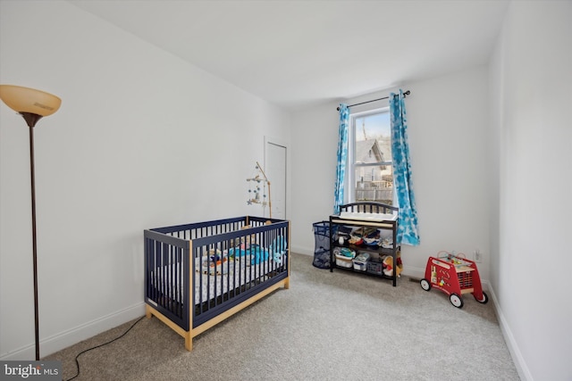 bedroom featuring a nursery area and carpet