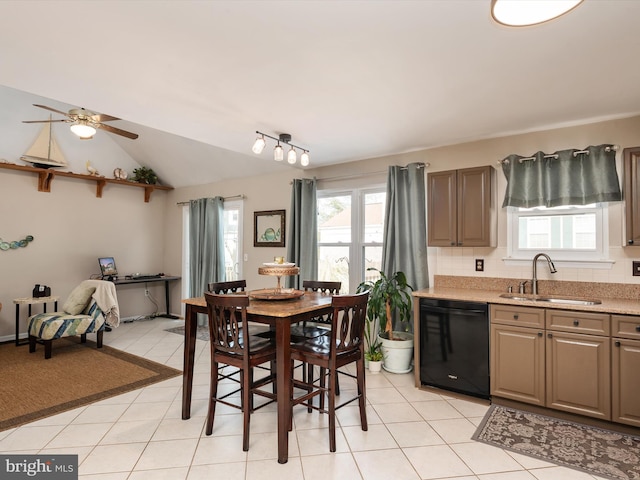 tiled dining space featuring vaulted ceiling, sink, and ceiling fan