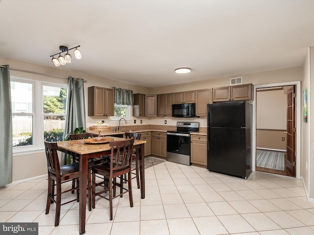 kitchen with sink, light tile patterned floors, and black appliances