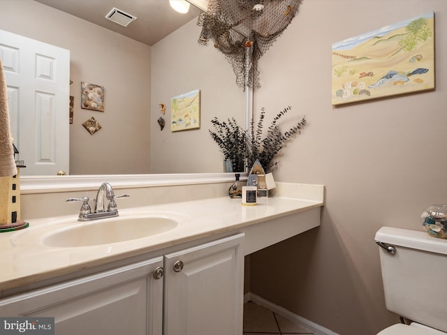 bathroom featuring vanity, tile patterned floors, and toilet