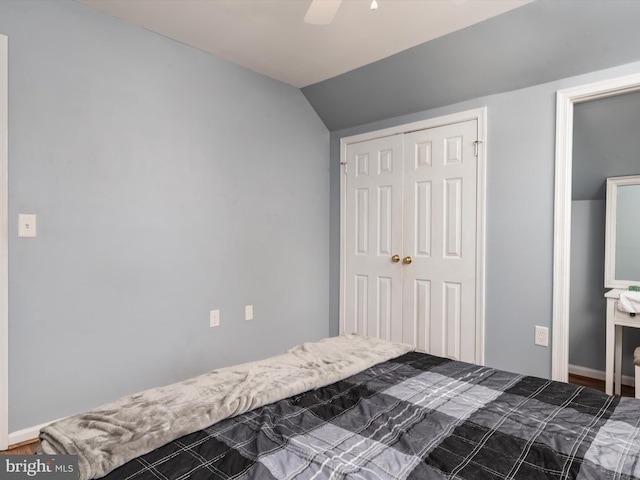 unfurnished bedroom with ceiling fan, vaulted ceiling, and a closet