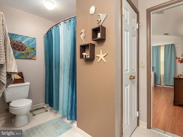 bathroom featuring a shower with curtain, tile patterned floors, and toilet