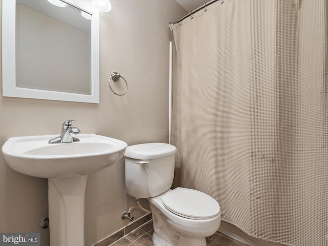 bathroom with toilet and tile patterned flooring