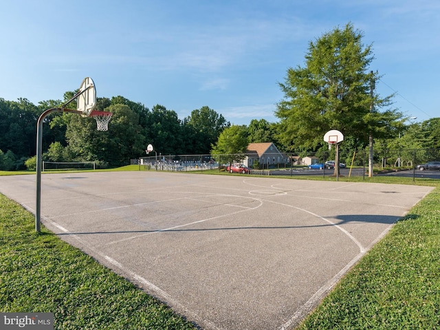 view of sport court with a lawn