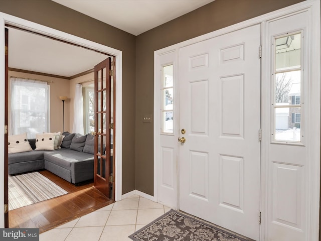 tiled foyer entrance with ornamental molding