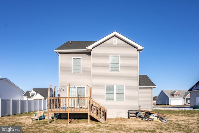 rear view of property with a deck and a yard