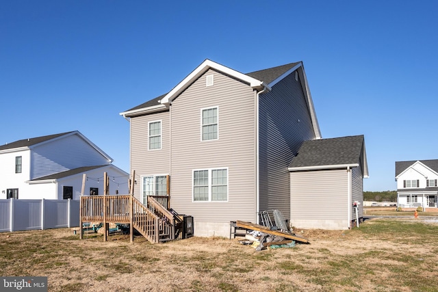 back of property with a deck and a yard