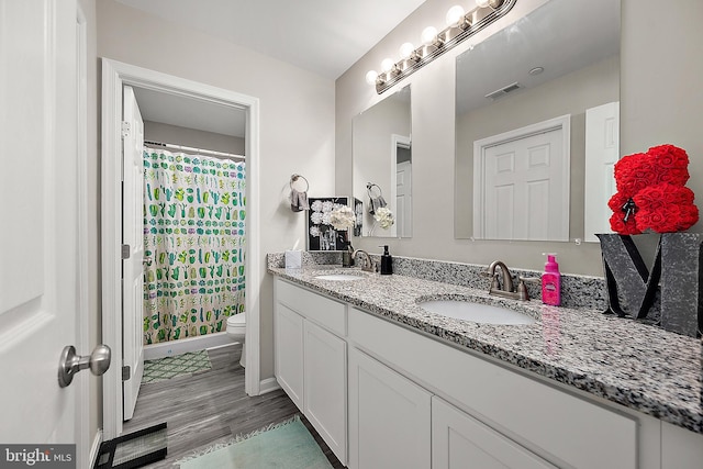 bathroom featuring hardwood / wood-style flooring, toilet, vanity, and a shower with shower curtain