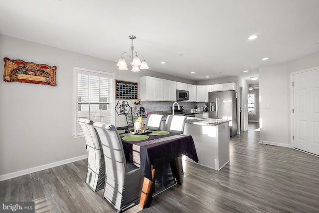 dining room with dark hardwood / wood-style floors, a chandelier, and plenty of natural light