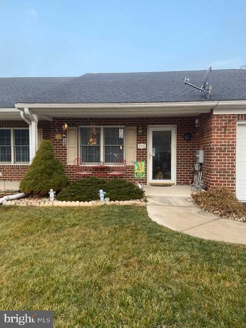 view of exterior entry with a lawn and a garage