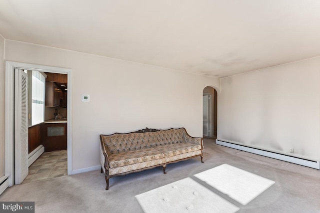 sitting room with light carpet and a baseboard heating unit