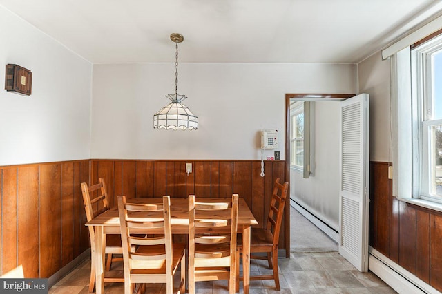 dining area with plenty of natural light and a baseboard heating unit