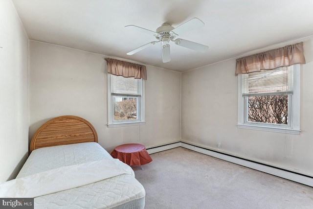 carpeted bedroom with baseboard heating and ceiling fan