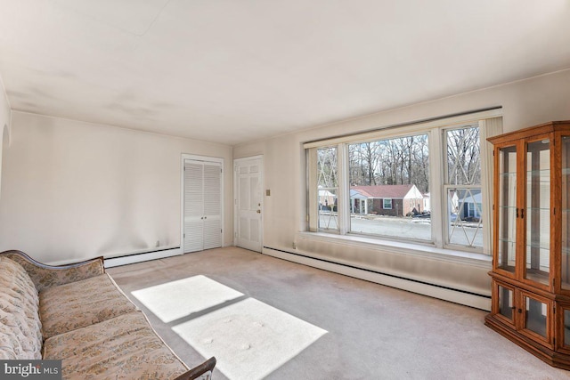 unfurnished living room featuring light carpet and a baseboard heating unit